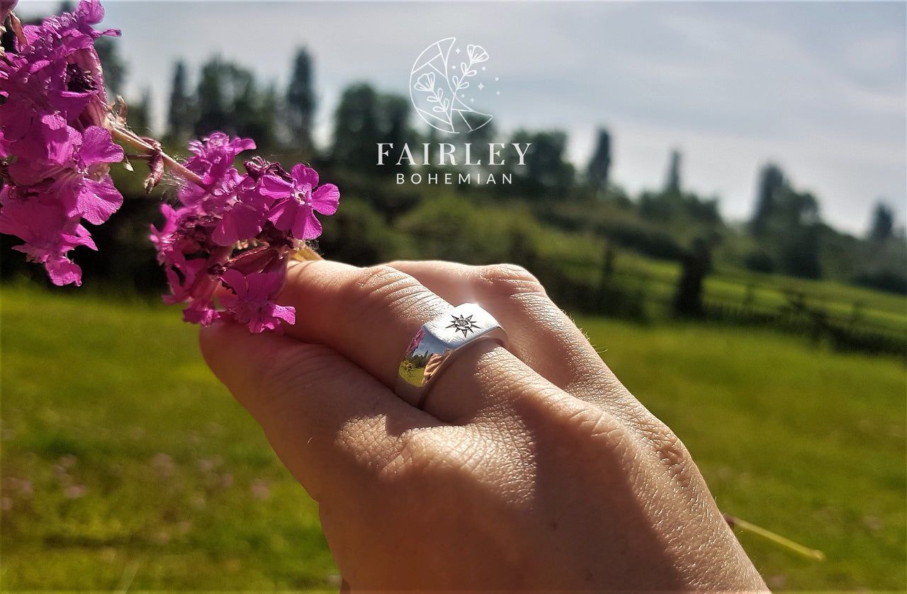 man made lab grown diamond set in sterling silver signet ring with flowers in field