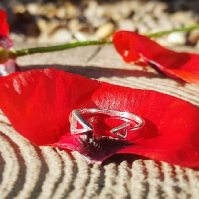 open arrow ring adjustable sterling silver ring on petal of flower in the sun